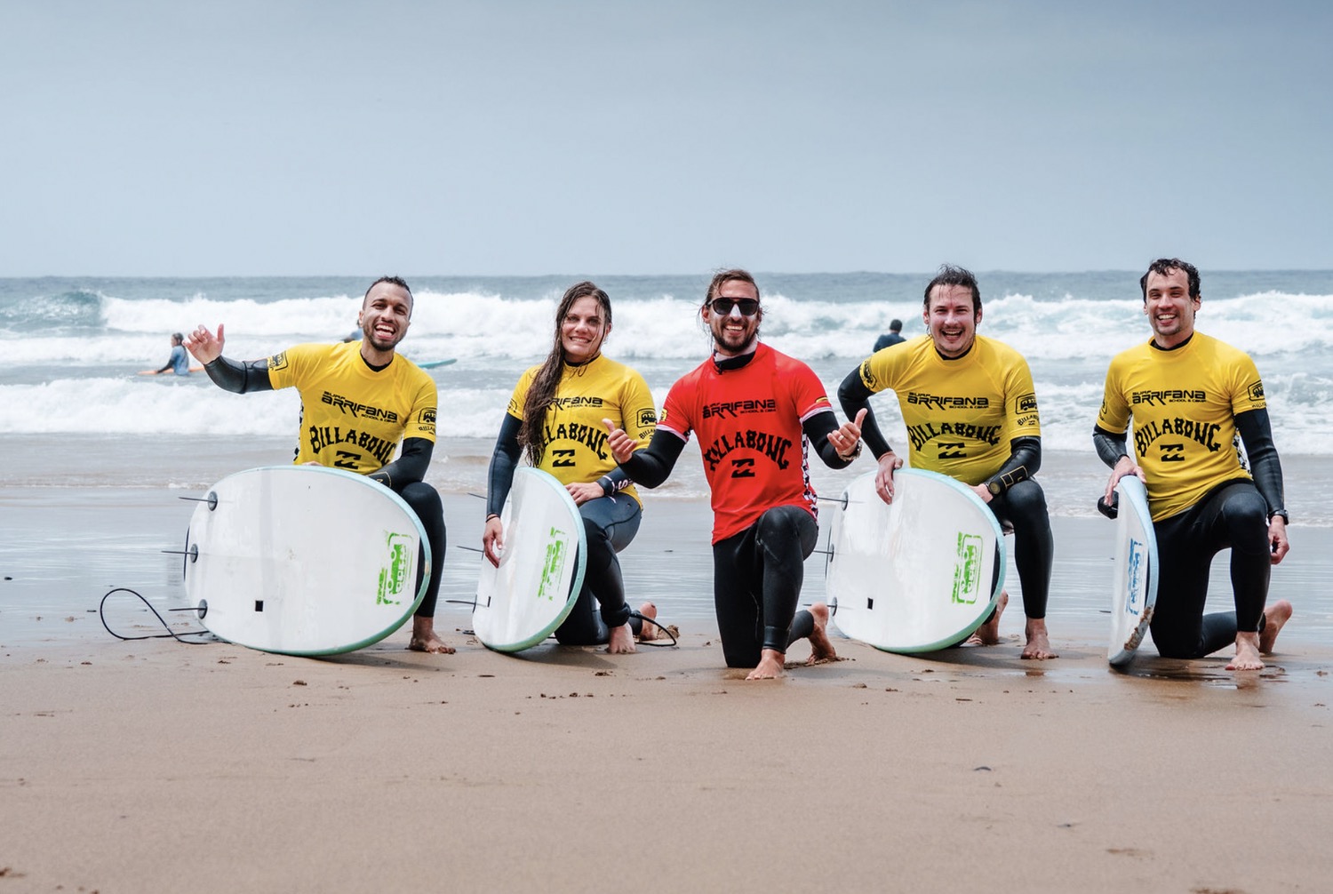 Grupo da Arrifana Surf School com pranchas Billabong na praia