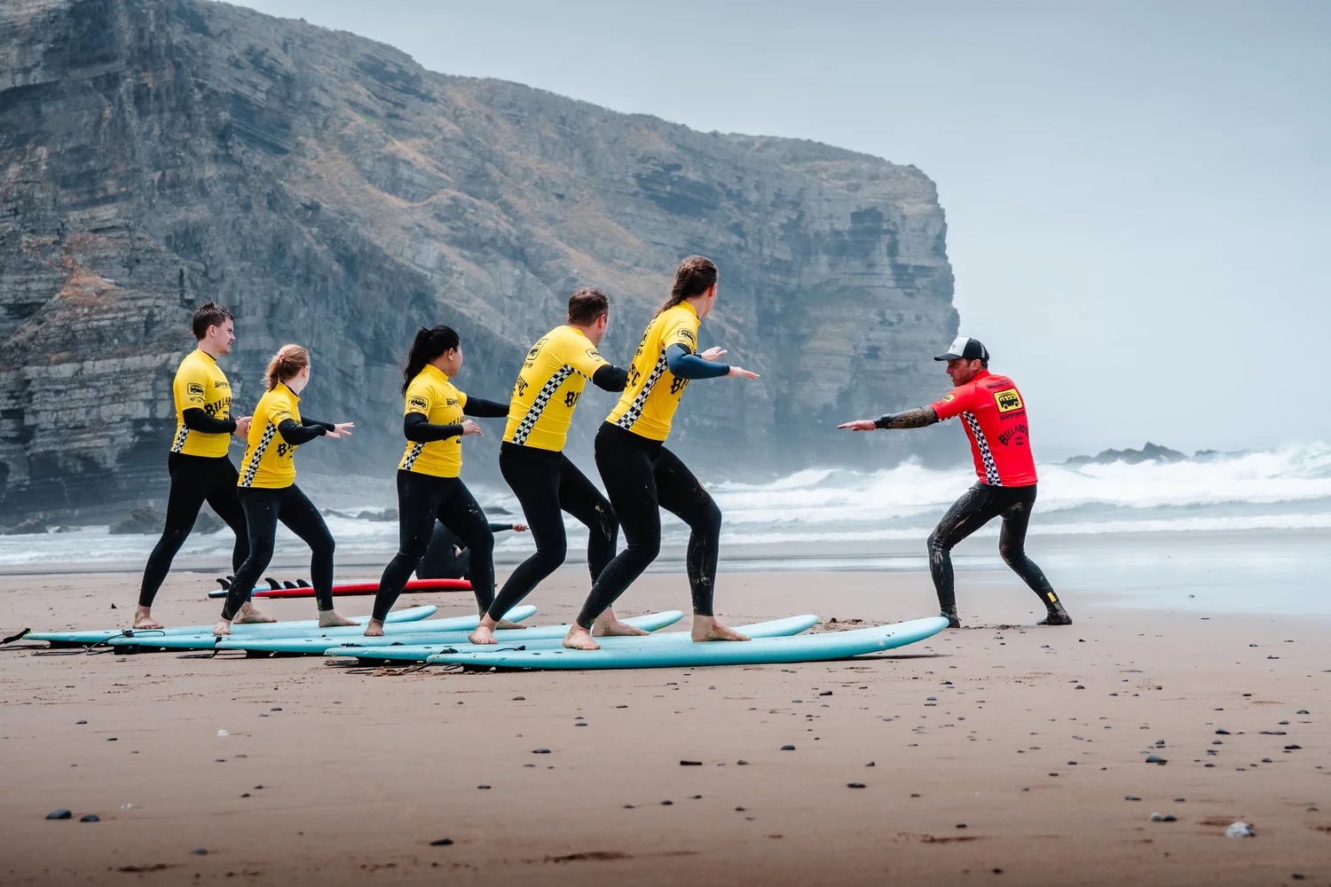 Aula de surf da Arrifana — prática de equilíbrio na areia antes da água