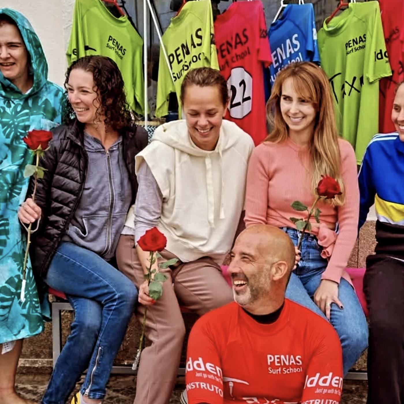 Penas Surf School — students and instructors outside the school, with the house jerseys behind