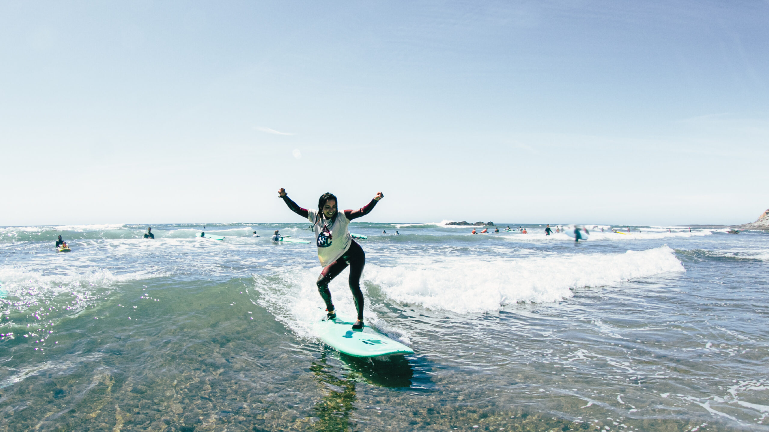 Aluna da West Coast Surf School de pé na onda, na Ericeira